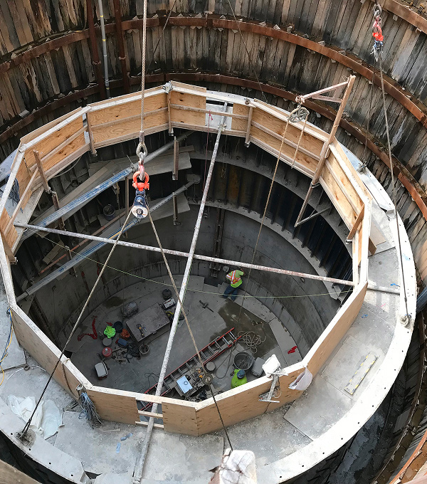 Mascaro Construction concrete structure construction featuring circular concrete walls, formwork systems, and specialty concrete installation within a deep excavation site.